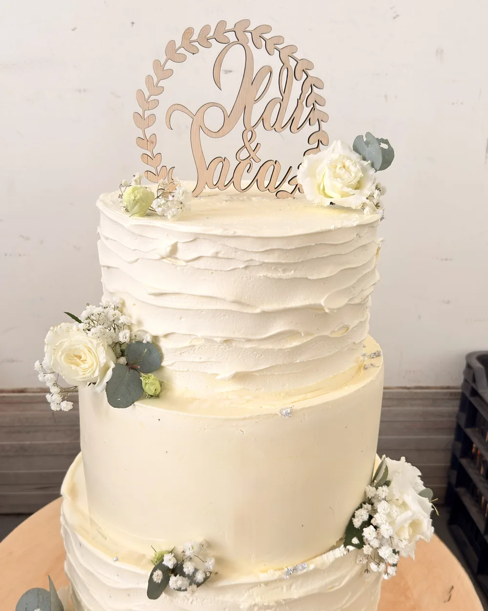 Fehér, kétemeletes esküvői torta virágdísszel